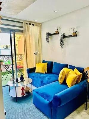 a blue couch with yellow pillows in a living room at Fundays Stay Casablanca in Casablanca