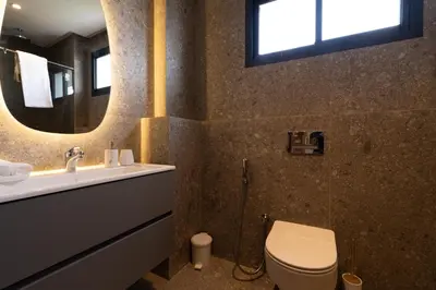 a bathroom with a toilet and a sink and a mirror at 3BR 3BA Family Apt Pool Gated Residence in Casablanca