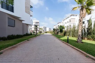 a brick road with palm trees and buildings at 3BR 3BA Family Apt Pool Gated Residence in Casablanca
