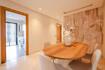 a dining room with a wooden table and chairs at 3BR 3BA Family Apt Pool Gated Residence in Casablanca