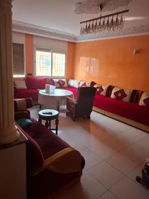 a living room with a red couch and a table at Appartement Chahdia in Casablanca
