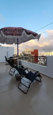 a patio with a table and an umbrella on a balcony at Privat Room in a Shard Apartment next to MOSQUÉE HASSAN 2 in Casablanca