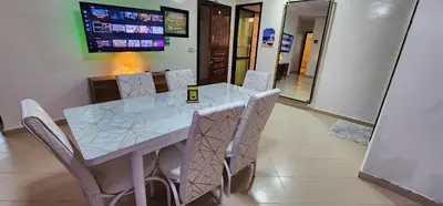 a dining room table with chairs and a television at Privat Room in a Shard Apartment next to MOSQUÉE HASSAN 2 in Casablanca