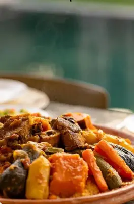 a plate of food with vegetables on a table at Villa Prestige in Bir Jedíd Saint-Hubert