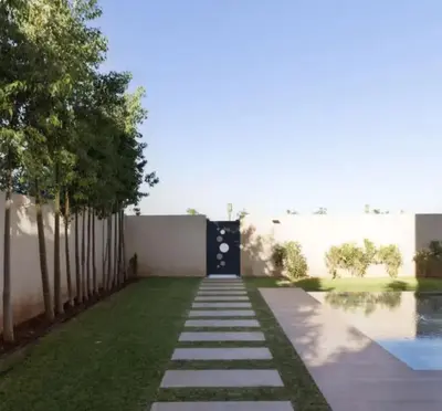 a walkway leading to a door in a yard at Villa Prestige in Bir Jedíd Saint-Hubert