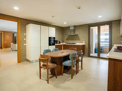 a kitchen with a table and chairs in a kitchen at The Pearl - 3 Chambres Marina - By AppartAli in Casablanca