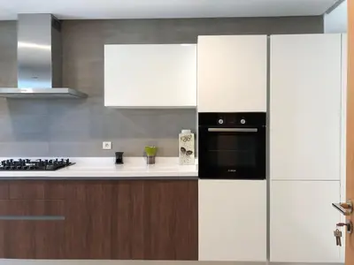 a kitchen with white cabinets and a black microwave at The Pearl - 3 Chambres Marina - By AppartAli in Casablanca