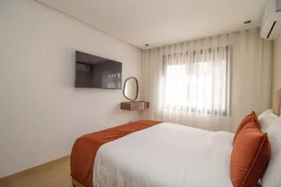 a white bedroom with a bed and a window at 2 Bedroom Apartment City Center in Casablanca