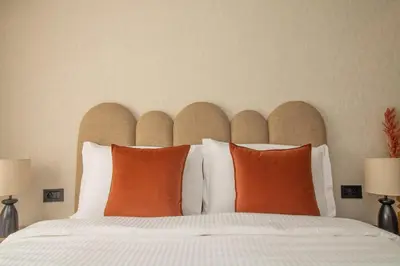 a bedroom with a bed with orange pillows at 2 Bedroom Apartment City Center in Casablanca