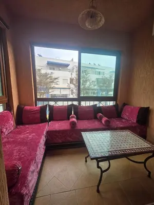 a living room with a red couch and a window at Dar Tourabi in Casablanca