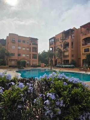 an apartment complex with a swimming pool and flowers at Dar Tourabi in Casablanca