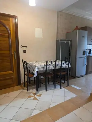 a kitchen with a table and chairs and a refrigerator at Dar Tourabi in Casablanca
