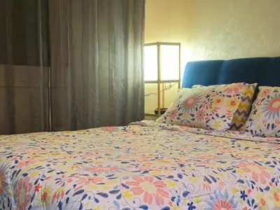 a bed with a colorful comforter and pillows at Chic studio! Comfort and perfect location! in Rabat