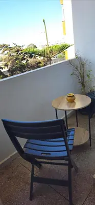 a blue chair and a table in front of a window at Chic studio! Comfort and perfect location! in Rabat