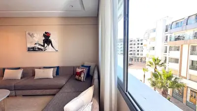 a living room with a couch and a large window at Family Trips or Professional Travels -By AppartAli in Casablanca
