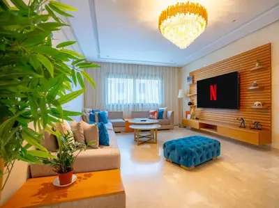 a living room with a couch and a tv at Family Trips or Professional Travels -By AppartAli in Casablanca