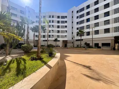 a large white building with palm trees in front of it at Family Trips or Professional Travels -By AppartAli in Casablanca