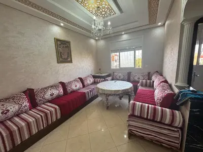 a living room with a couch and a table at Appatement authentique 7mn Hay Riad in Temara