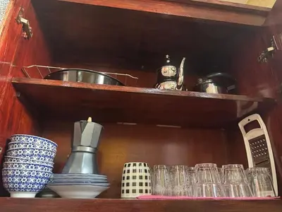 a wooden shelf with dishes and cups on it at Appatement authentique 7mn Hay Riad in Temara