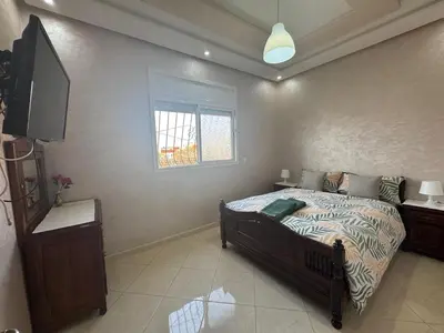 a bedroom with a bed and a flat screen tv at Appatement authentique 7mn Hay Riad in Temara