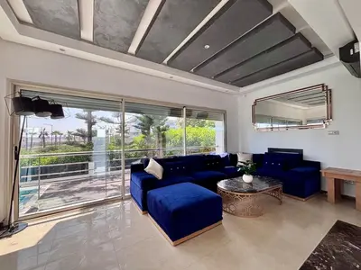 a living room with a blue couch and a large window at Villa Miraluna ,Jacuzzi Retreat in Tamaris