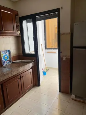 a kitchen with a door open to a kitchen with a refrigerator at Saad home in Casablanca