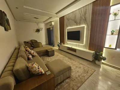a living room with a couch and a flat screen tv at Sables d'or flat apartement in El Harhoura