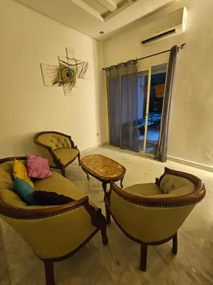 a living room with three chairs and a table at Sables d'or flat apartement in El Harhoura