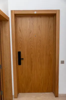 a wooden door with a black handle in a room at Homerest appartement Casablanca in Casablanca