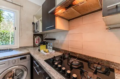 a kitchen with a stove top oven next to a washing machine at Villa Zen, piscine privée et plage in Casablanca
