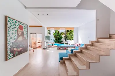 a living room with stairs and a painting on the wall at Villa Zen, piscine privée et plage in Casablanca
