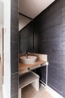 a bathroom with a sink and a black wall at Villa Zen, piscine privée et plage in Casablanca