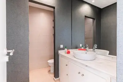 a bathroom with a sink and a toilet and a mirror at Villa Zen, piscine privée et plage in Casablanca