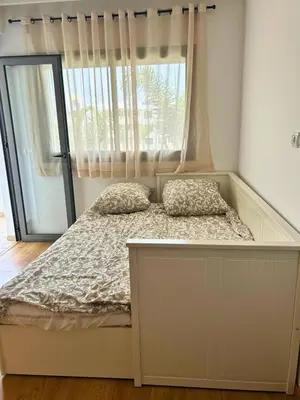 a bed with two pillows in a room with a window at Beautiful Family Apartment Beach Paradise Residence in Pont Blondin