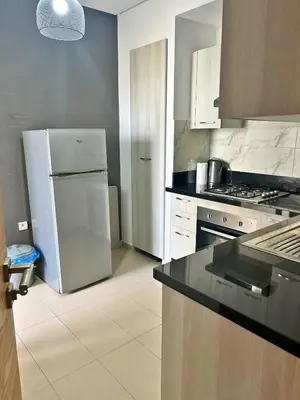 a kitchen with a white refrigerator and a stove at Beautiful Family Apartment Beach Paradise Residence in Pont Blondin