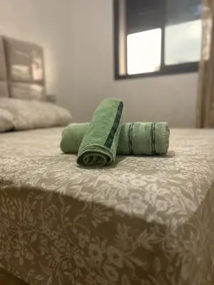 two green towels sitting on top of a bed at Charming Apartment Residence Ocean Park Pool, Sea in Aïn Harrouda