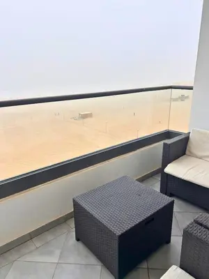 a room with a table and a couch and a basketball court at Beautiful Apartment Residence Miramar Sea View in Mohammedia