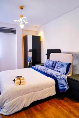 a bedroom with a large bed with blue pillows at Modern Apart Heart of Casablanca Perfect Location in Oulad Akkou