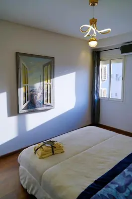 a bedroom with a large bed and two windows at Modern Apart Heart of Casablanca Perfect Location in Oulad Akkou