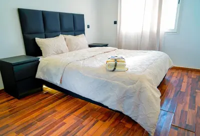 a bedroom with a large bed with a black headboard at Modern Apart Heart of Casablanca Perfect Location in Oulad Akkou