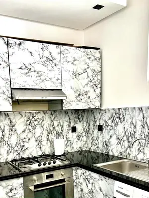 a kitchen with black and white marble wallpaper at Modern Apart Heart of Casablanca Perfect Location in Oulad Akkou