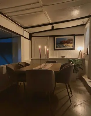 a dining room with a table with chairs and candles at Joumaira beach in Temara