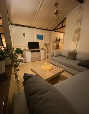 a living room with a couch and a table with candles at Joumaira beach in Temara
