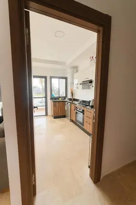 a kitchen with a door open to a living room at Jolie appartement piscine bord de mer Haut standing in Mansouria