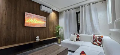 a living room with a white couch and a tv at Le Casablanca in Maarif