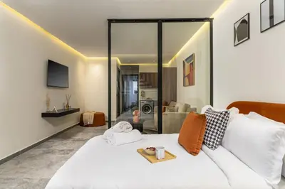 a bedroom with a white bed and a living room at The Nest Residence by GoodMove - Gauthier Casablanca in Casablanca