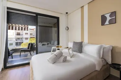 a bedroom with a large white bed and a balcony at The Nest Residence by GoodMove - Gauthier Casablanca in Casablanca