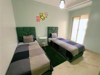 a room with two beds and a table in it at Casa Stay in Casablanca