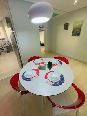 a white table with red chairs and plates on it at Casa Stay in Casablanca