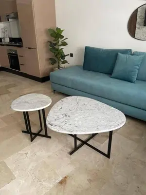 a living room with a blue couch and two tables at Studio de lux in Casablanca